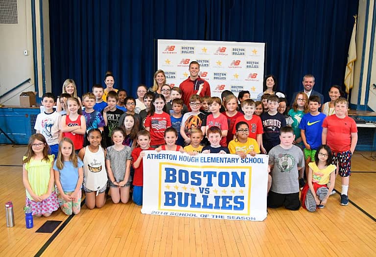 Justin Turri and a large group of children posing and holding a Boston vs. Bullies banner