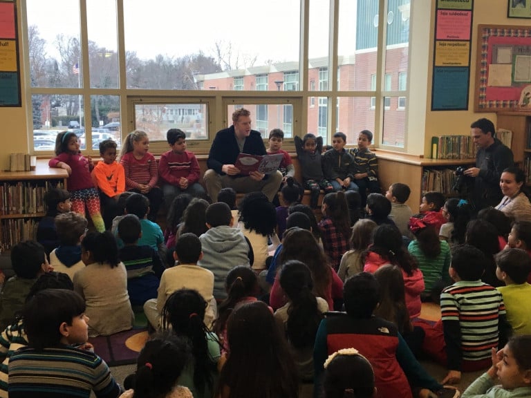 Brian Scalabrine seated talking to a group of children in a library