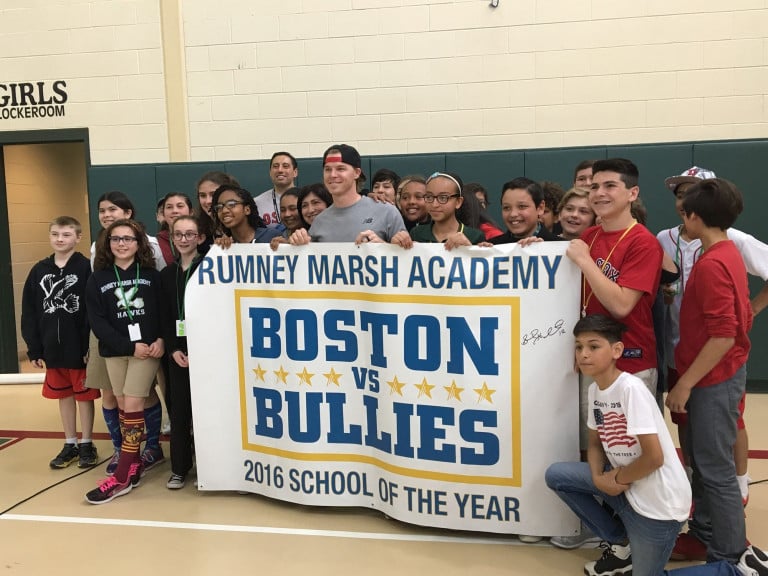 Brock Holt holding a Boston vs. Bullies banner with a group of children