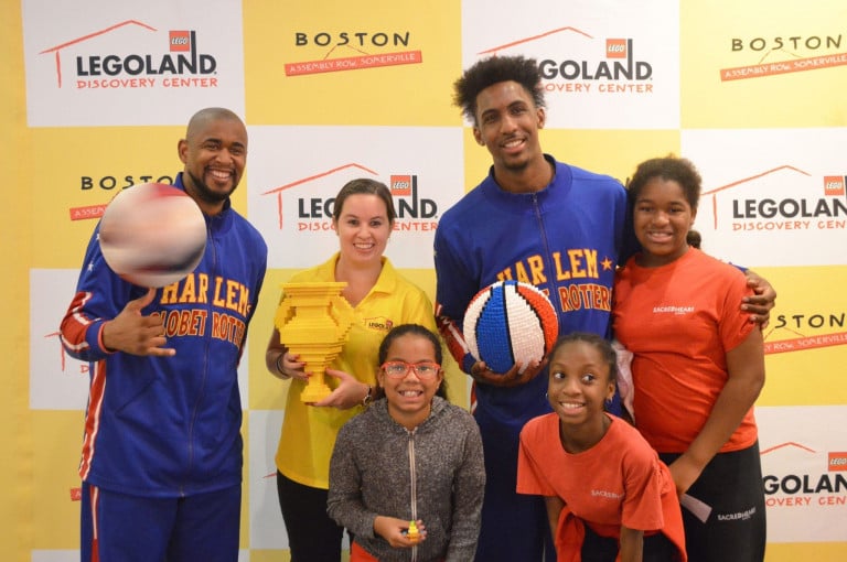 Two Harlem Globetrotters posing with a woman and two children