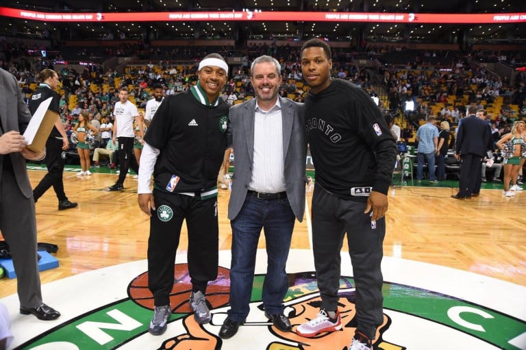 Rusty Sullivan standing at center court of the TD Garden posing with Isaiah Thomas and Kyle Lowry