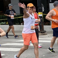 Patricia Arnold waving while walking in a marathon