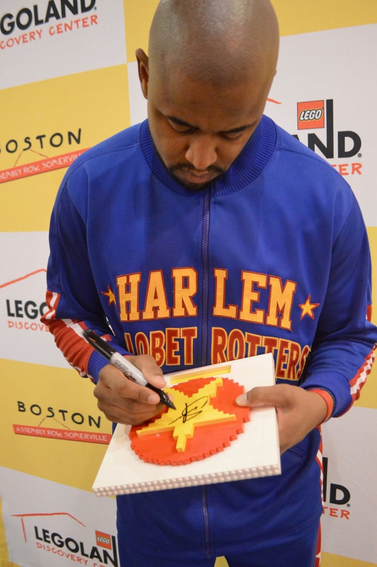 A Globetrotter signing a lego star plaque