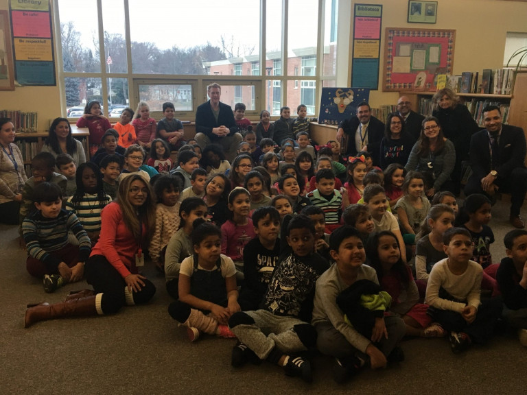 Brian Scalabrine posing for a photo with a group of children and adults in a library