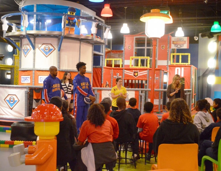 Two Globetrotters and two woman speaking to a group of children at Legoland